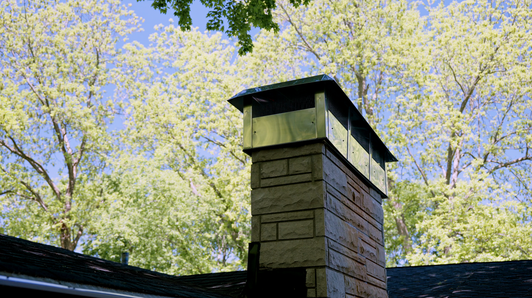 hero background - tall stone chimney with metal cap and blue sky